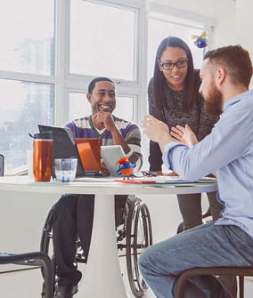 people sitting around a table talking and smiling